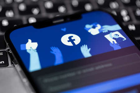 Facebook start page in mobile app on screen smartphone iPhone. Facebook is the largest and most...