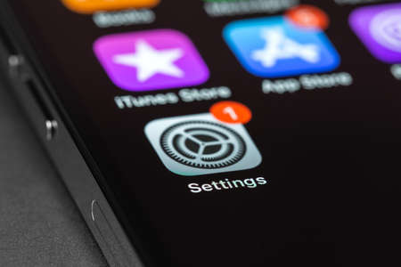 iPhone with Settings, iOS update on screen, interface icons closeup. Apple is a multinational technology company. Moscow, Russia - September 5, 2021のeditorial素材