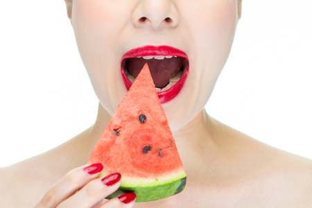 Fashion woman enjoy eating watermelon with red lips, sexyの写真素材