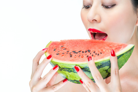 Fashion woman enjoy eating watermelon red lips,  biteの写真素材