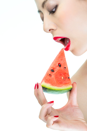 Fashion woman enjoy eating watermelon with red lips, bite, fashionの写真素材