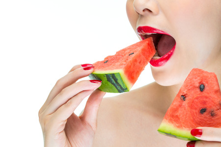 Fashion woman enjoy eating watermelon with red lips, Greedy, biteの写真素材