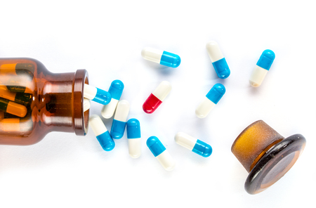 blue capsules and red capsules with  bottle, healthcare and medicine medication cureの写真素材