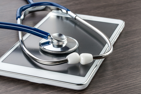 digital tablet and stethoscope on wood desk in Doctor workplaceの写真素材