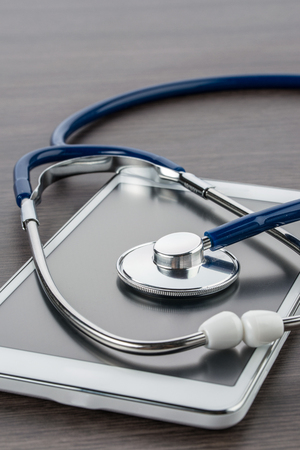 digital tablet and stethoscope on wood desk in Doctor workplaceの写真素材