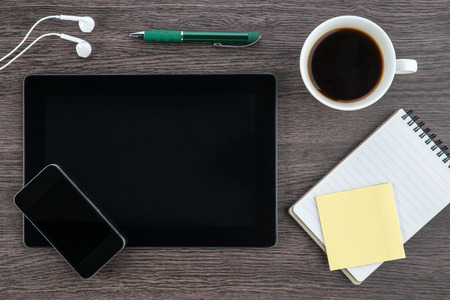 Tablet, headphone, notebook and smart phone with coffee on the deskの写真素材