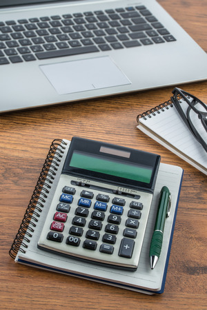 laptop, notebook and pen with calculator on the desk finance planの写真素材