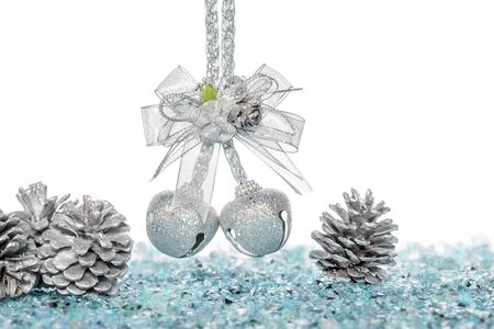 Luxury Silver jingle Bells and Pine Cone on Snow, hanging Decoration, isolated on whiteの写真素材
