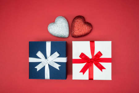 gift box wrap silk ribbon with love heart shape on red backgroundの写真素材