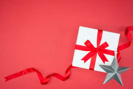 luxury color gift box for holiday event silk wrap snowflake on red background isolatedの写真素材