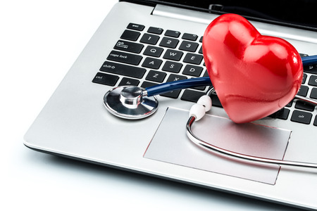 Cardiologist, heart disease research, stethoscope and heart shape on laptop keyboardの写真素材