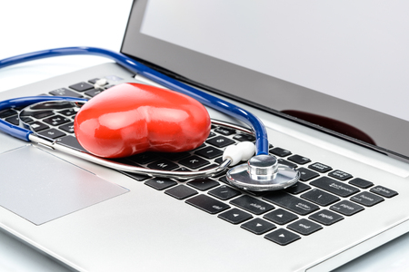 Cardiologist, heart disease research, stethoscope and heart shape on laptop keyboardの写真素材