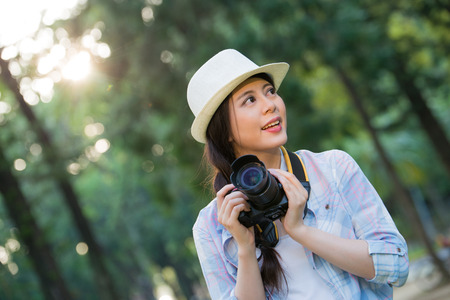 Beautiful asian girl smiling with digital camera photographing, outdoor travel