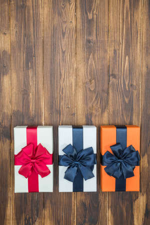 luxury color gift box for holiday event with beautiful silk wrap on Wood background isolated