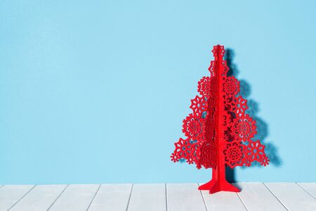 Paper christmas tree made of snowflakes on white wooden Flooringの写真素材