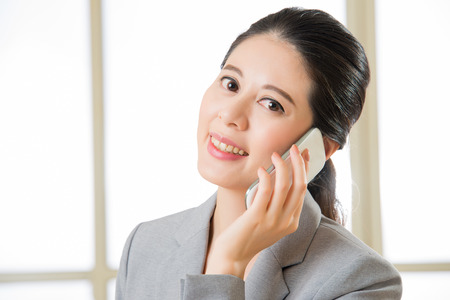 Smiling Business asian Woman talking on a Mobile phone in officeの写真素材