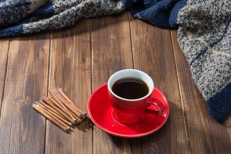 Cinnamon, coffee and blanket on wooden floorの写真素材
