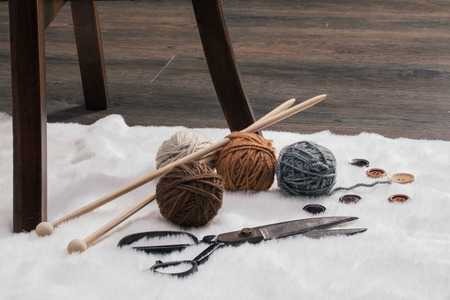 button, scissors and yarn ball on carpet, handmadeの写真素材