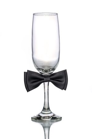 empty champagne glass  with bow tie on white backgroundの写真素材