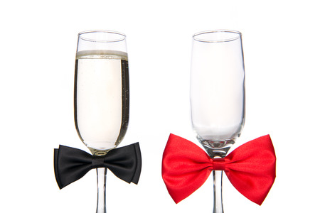 Glass of champagne with bow tie on white backgroundの写真素材