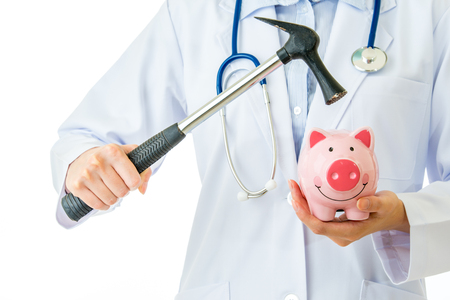 doctor with piggybank and hammer on white backgroundの写真素材