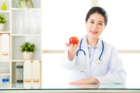Young asian nutritionist holding an apple, healthy eatingの写真素材