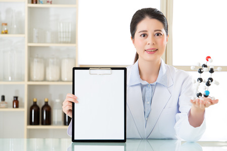 Happy smile asian female scientist holding clipboard with molecular modelの写真素材