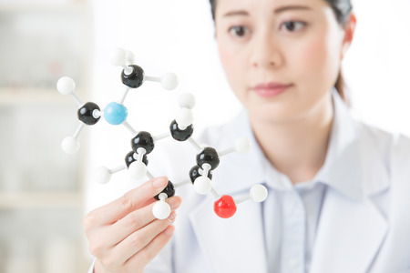asian female scientist holding and looking at molecular model doing the Science research for human longevity Antidoteの写真素材