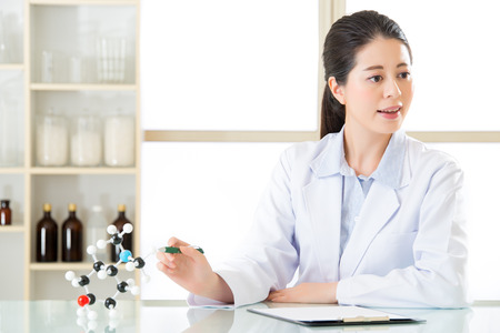 asian female scientist teacher point at molecular model explain Scientific wonders with a green penの写真素材