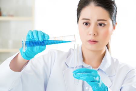 Asian female scientist Researcher observing indicator color shift in laboratoryの写真素材