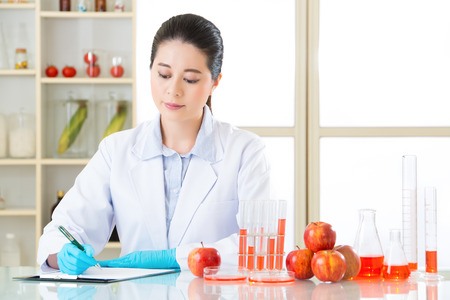 Asian female scientist Recording her data is important for genetic modificationの写真素材
