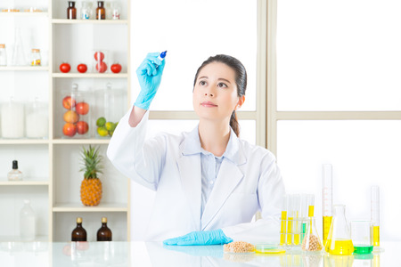 Asian female scientist recording the result on writing glass in laboratoryの写真素材