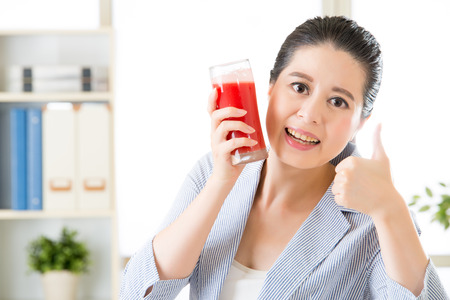 asian business woman good to drinking fresh watermelon juice in officeの写真素材