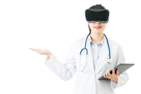 asian female doctor use digital tablet control virtual reality hand up. VR headset glasses device. white isolated background. medical and health conceptの写真素材