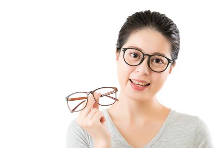 young smilling asian woman hold new vision glasses. isolated on white background. medical and health conceptの写真素材