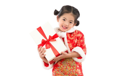 young Asian little girl happy excited with red gift box with wearing cheongsam. isolated on white background. holiday and festival concept.の写真素材