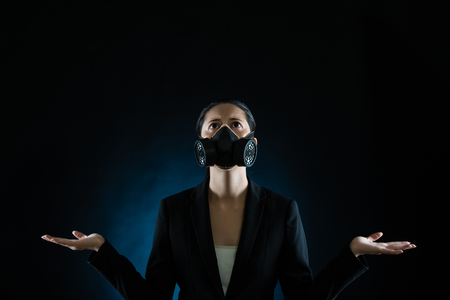 business woman wearing a mask pray for pollution environment become clear on black background concept. mixed race asian chinese modelの写真素材