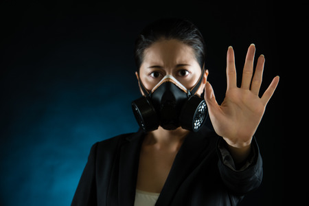 woman in protective mask with reject gesture hand. Atmospheric pollution smog influence on people health concept. mixed race asian chinese modelの写真素材