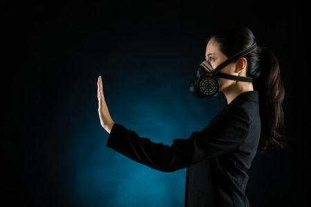 Asian business woman showing reject hand gesture wearing a face mask to protect against pollution. mixed race asian chinese modelの写真素材