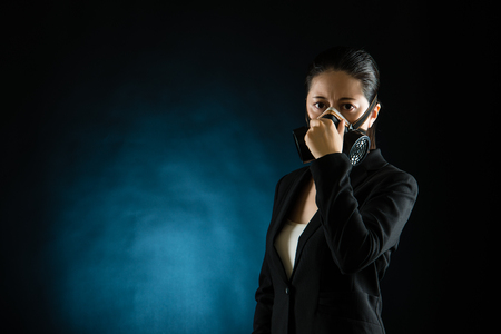 business woman smell stink wearing gas mask, isolated on white background. mixed race asian chineseの写真素材