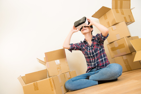 Cheerful woman looking at construction house plan with VR headset device. mixed race asian chinese modelの写真素材