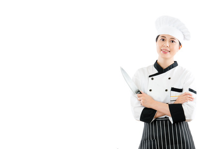 young chef with a cutting knife and showing smiling standing on a blank copyspace with hands crossed isolated white wall background in advertising area.の写真素材