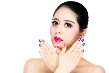 asian multi colored black hair girl gaze with art nail hands crossed on copyspace of white background. advertising of cosmetic company concept.の写真素材