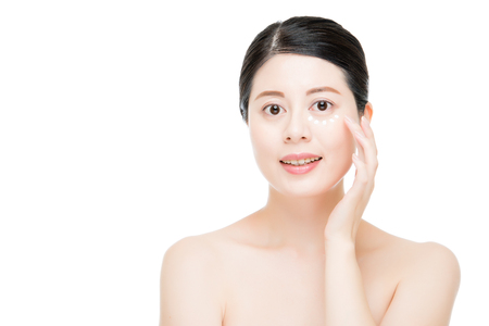 Young Asian chinese lady use eye cream maintain young age and keep skin better bright isolated on white background. fashion beauty and health concept.の写真素材