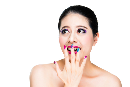 laughing beautiful girl using hand with art nails cover the opened mouth and colorful eyes watching copyspace on air isolated on white background.の写真素材