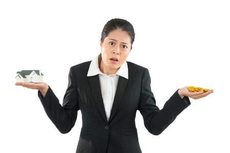 asian bank manager showing house and coin arms out shrugs shoulders on white background. young girl looking have problem about saving.の写真素材