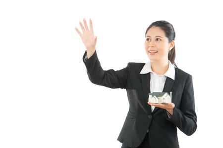 trustworthy lady hand pushing on a touch screen interface. asian women want to catch something on white background. beautiful agent smiling.の写真素材