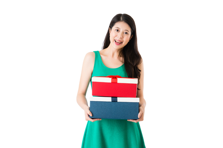 smiling young girl hold red and blue boxes with beautiful green dress in the special day isolated on white wall background with copyspace.の写真素材