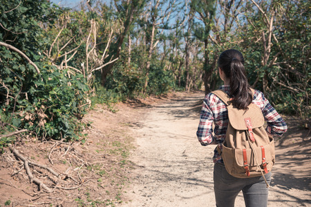 beautiful woman hiker hike on forest trail and looking away for back view on Aguamansa, Tenerife, Spain. student visiting natural landscape concept.の写真素材