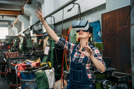 young milling machine female staff through 3D virtual reality devices watching factory working...
